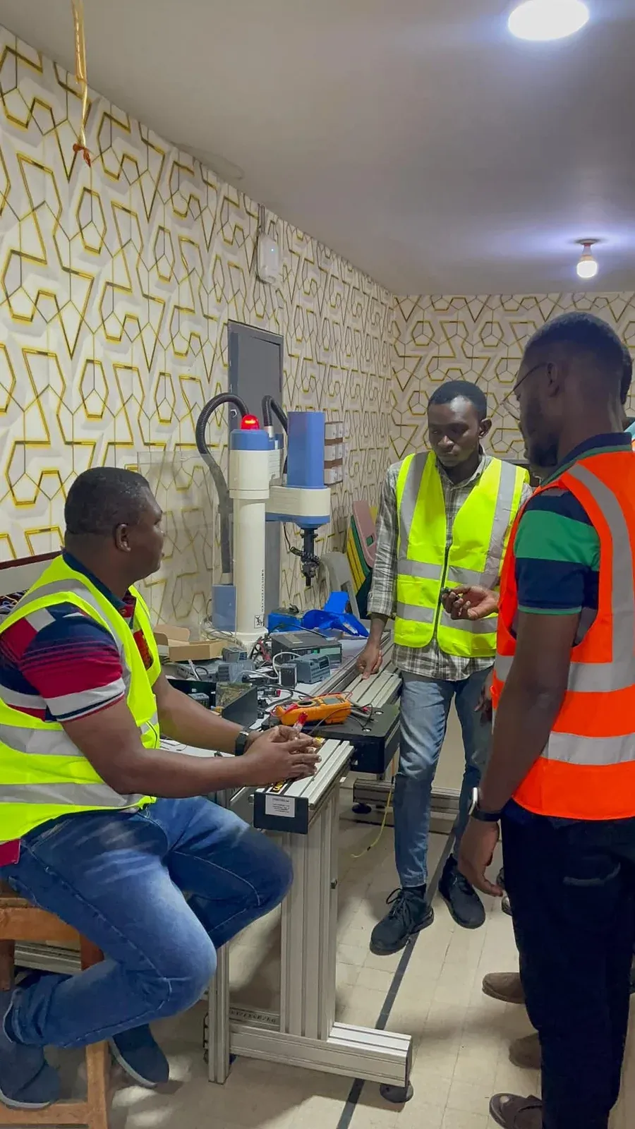 Trainees and an instructor working at an industrial automation trainer station