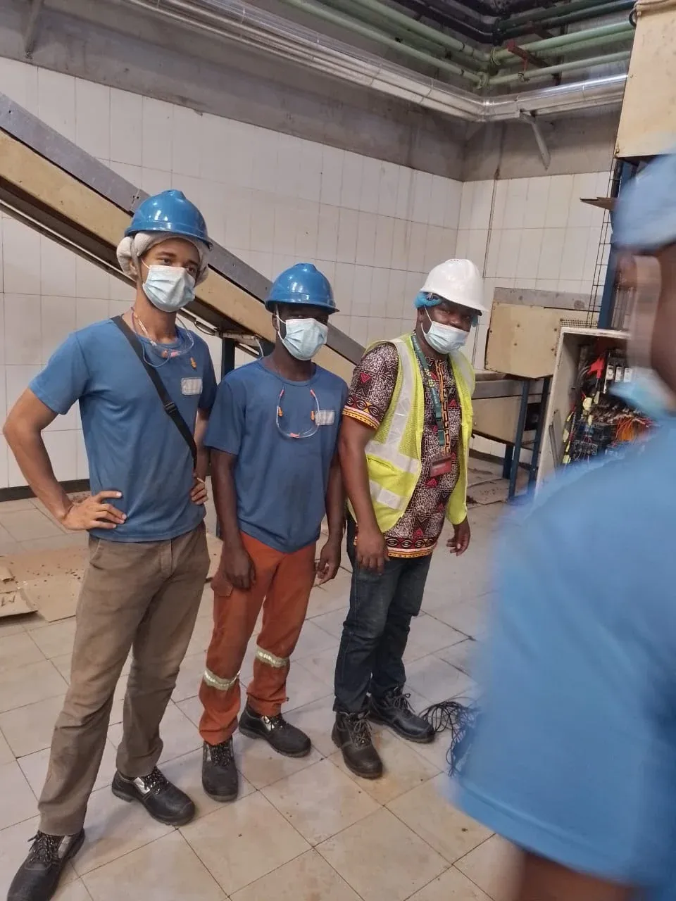 Remotec Ltd engineer and client technicians in hard hats beside a motor control panel