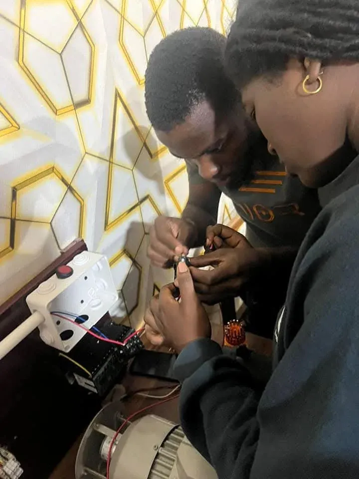 Two trainees wiring a motor control circuit together