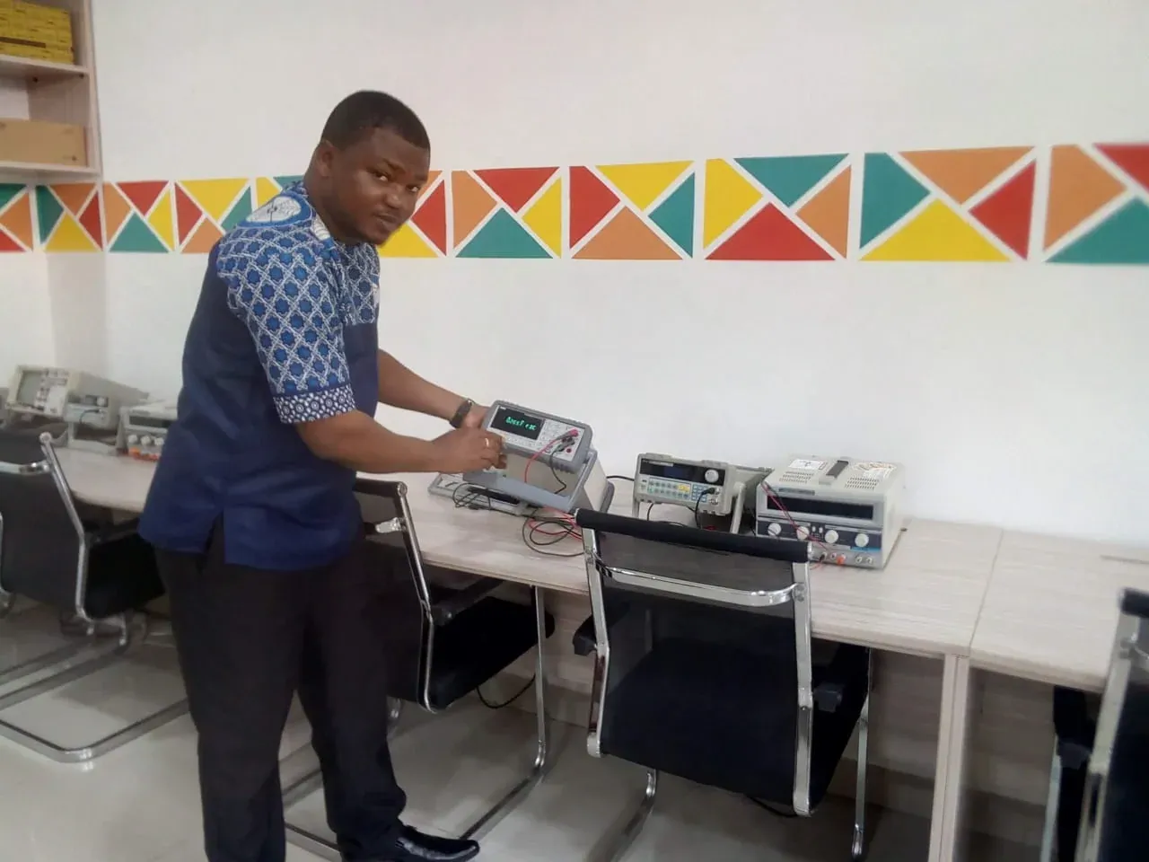 Instructor setting up bench power supplies in a training lab